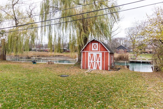 view of outbuilding with a water view and a lawn