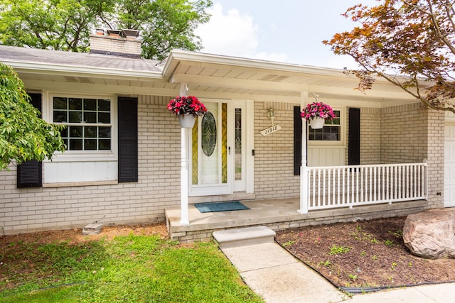 21918 Knudsen Dr, Grosse Ile, MI 48138 - property entrance featuring a porch, brick siding, and a chimney