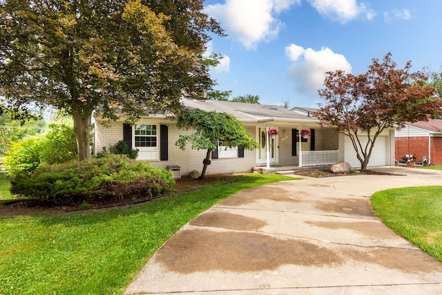 21918 Knudsen Dr, Grosse Ile, MI 48138 - view of front of home featuring brick siding, covered porch, an attached garage, a front lawn, and concrete driveway