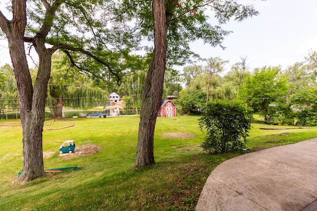 21918 Knudsen Dr, Grosse Ile, MI 48138 - surrounding community with a shed, an outdoor structure, a yard, and view of scattered trees