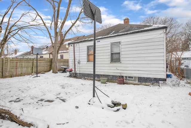 view of snow covered back of property