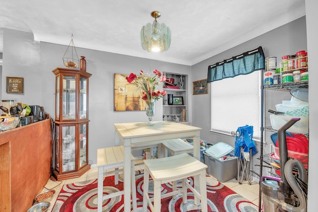 dining space featuring light tile patterned flooring and built in shelves