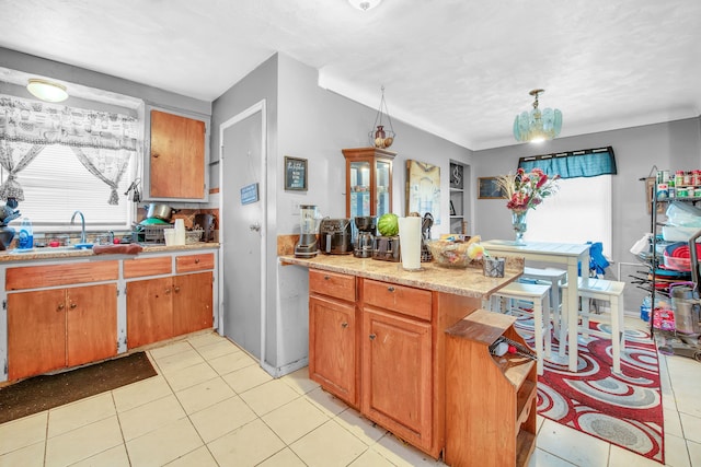 kitchen featuring light tile patterned floors, pendant lighting, and sink