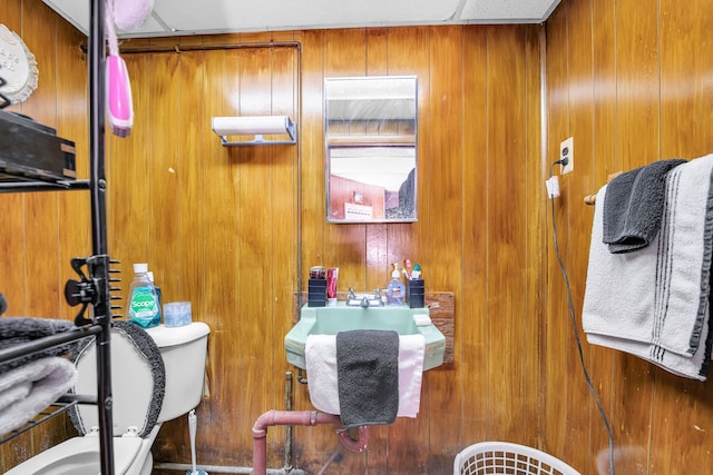 bathroom featuring toilet, a paneled ceiling, and wood walls