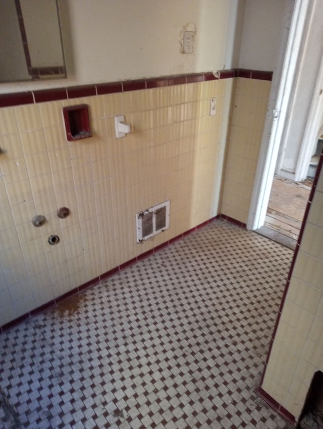 clothes washing area with tile walls