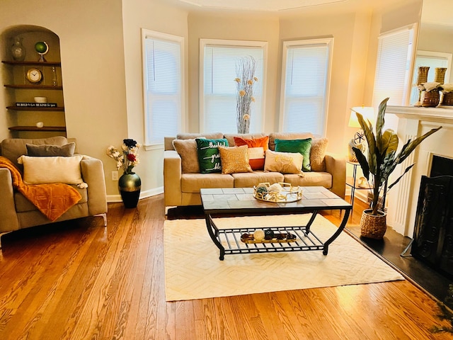 living area with built in shelves and wood-type flooring