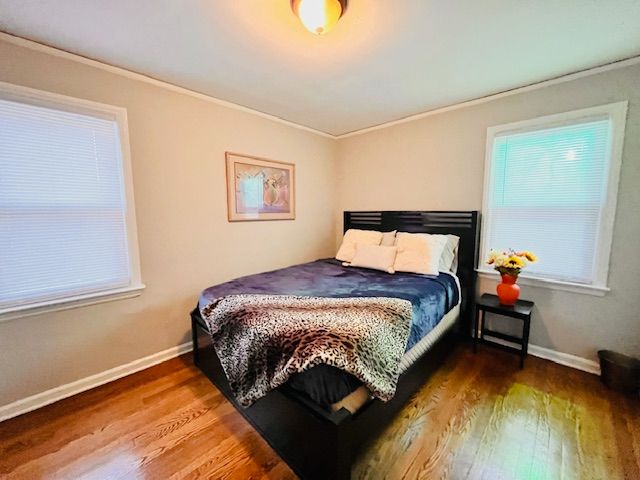 bedroom featuring hardwood / wood-style flooring and crown molding