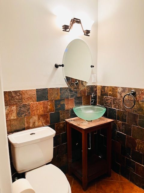 bathroom featuring tile patterned flooring, vanity, tile walls, and toilet