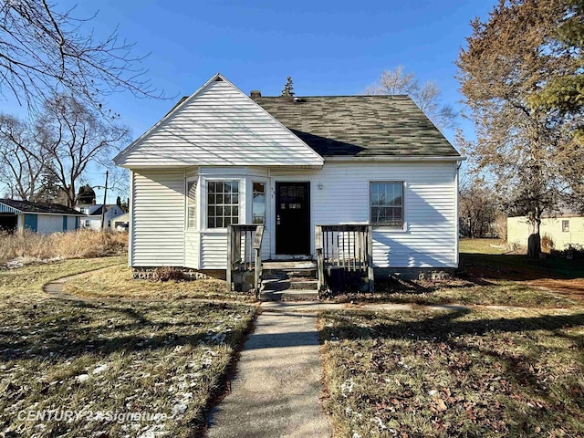 bungalow-style home with a front yard