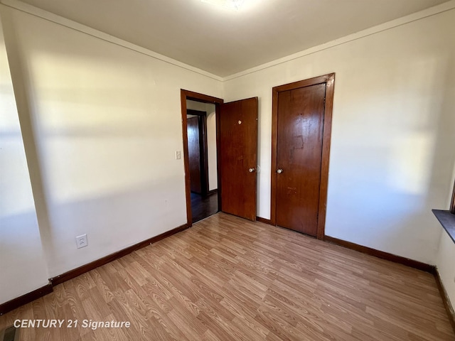 unfurnished bedroom with light wood-type flooring and crown molding