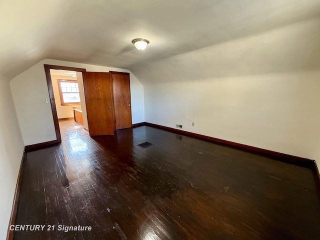 additional living space featuring lofted ceiling and hardwood / wood-style floors