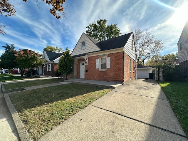 view of front of house with a front yard, a garage, and an outdoor structure