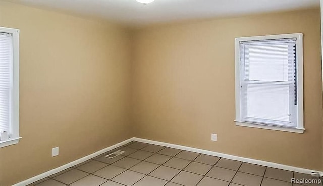 spare room featuring light tile patterned flooring