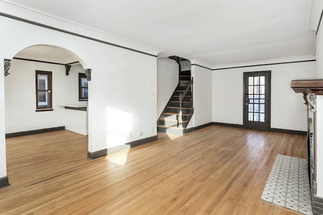 unfurnished living room featuring ornamental molding and light hardwood / wood-style floors