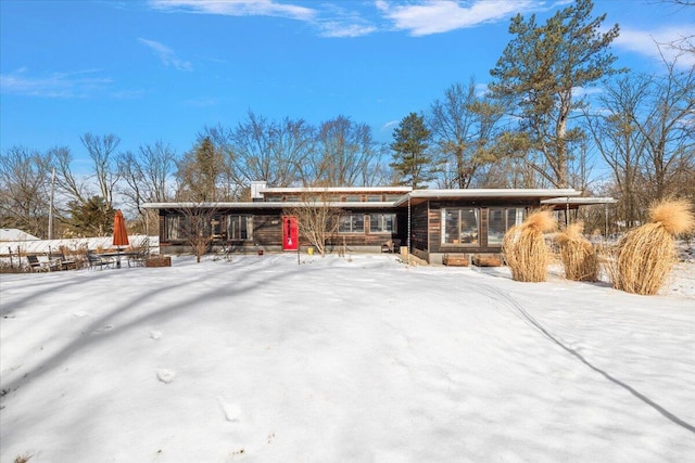 view of snow covered rear of property