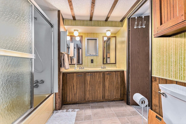 full bathroom featuring toilet, wood walls, bath / shower combo with glass door, beamed ceiling, and vanity