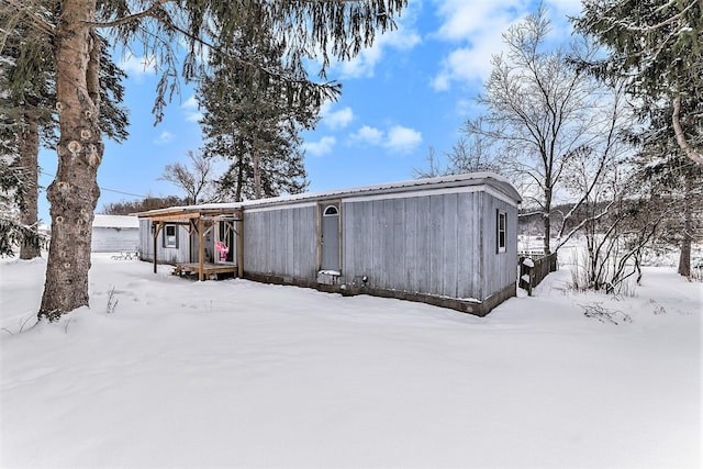 view of snow covered back of property