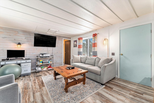 living room featuring light hardwood / wood-style floors and wooden walls