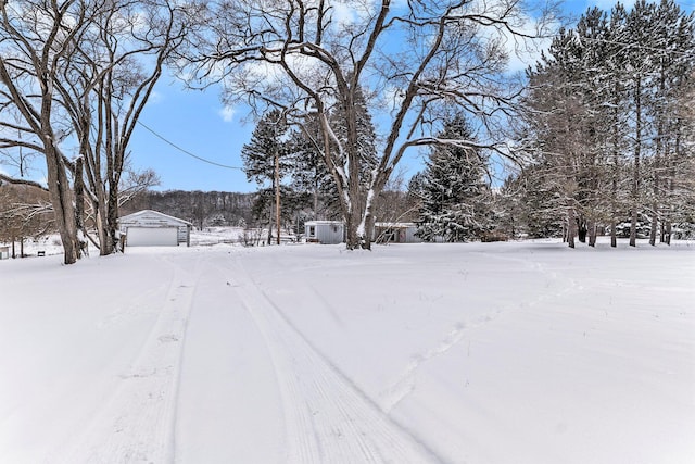 snowy yard with a garage