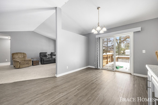 unfurnished dining area featuring a notable chandelier, dark hardwood / wood-style flooring, and lofted ceiling