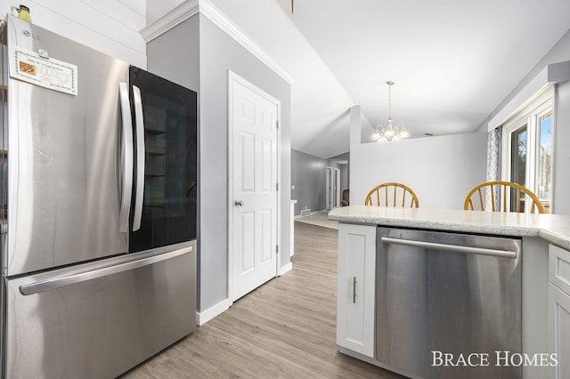 kitchen with a chandelier, appliances with stainless steel finishes, light wood-type flooring, white cabinets, and lofted ceiling