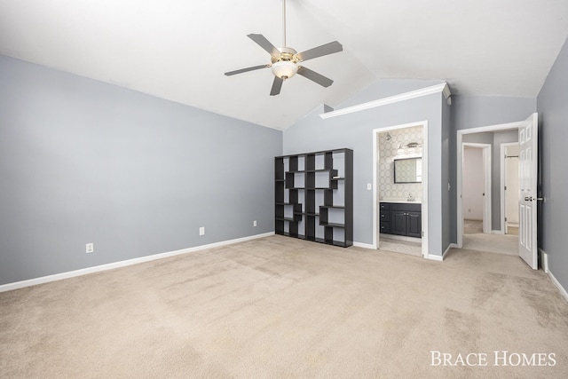 unfurnished bedroom featuring lofted ceiling, light carpet, connected bathroom, and ceiling fan