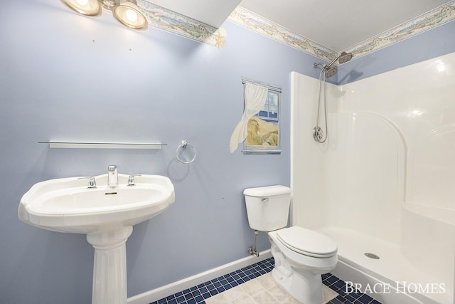 bathroom with toilet, a shower, and tile patterned floors