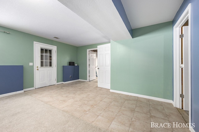 carpeted spare room featuring a textured ceiling