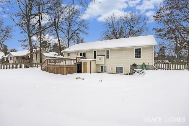 snow covered property with a wooden deck