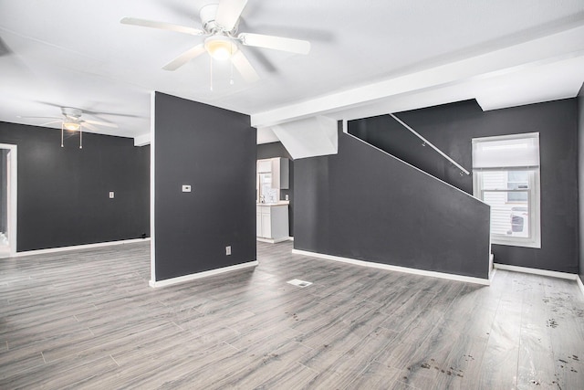 unfurnished living room featuring ceiling fan and hardwood / wood-style floors