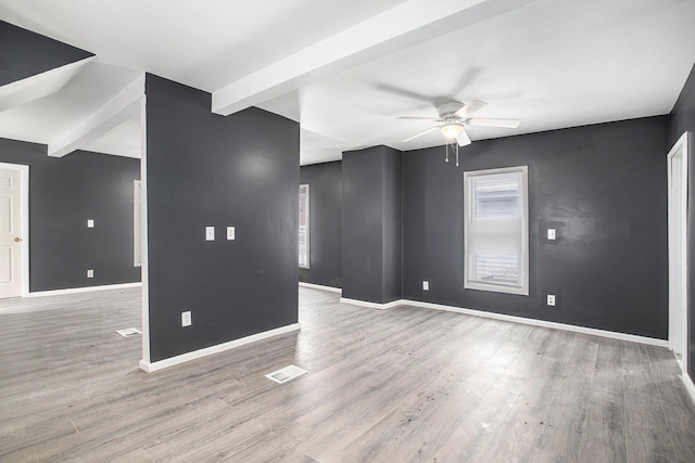 unfurnished room featuring ceiling fan, beamed ceiling, and hardwood / wood-style flooring