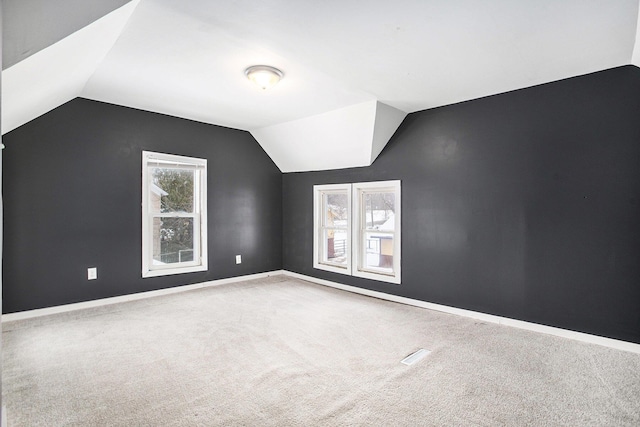 additional living space featuring lofted ceiling and carpet floors