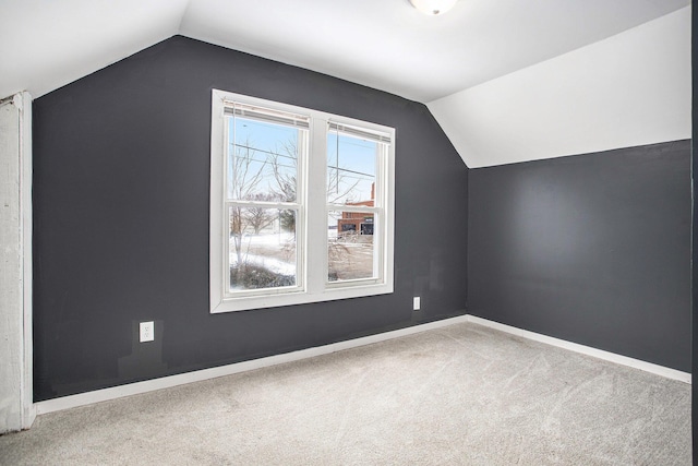 additional living space featuring lofted ceiling and light colored carpet