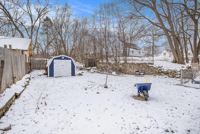 yard layered in snow featuring a storage unit