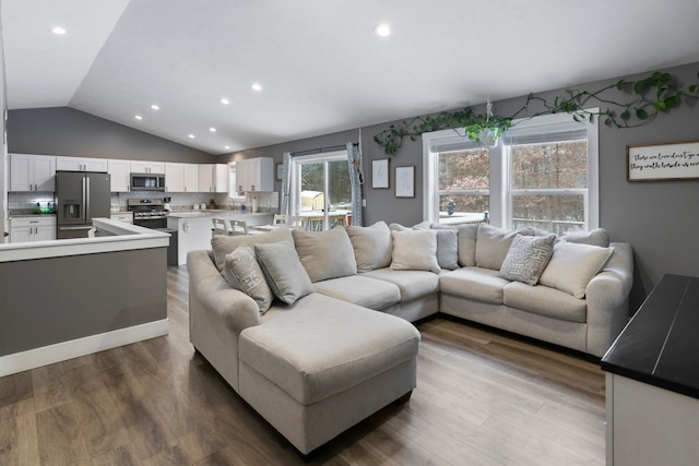 living room with wood-type flooring and vaulted ceiling