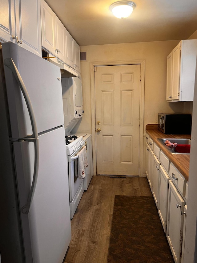 kitchen with white appliances, white cabinets, dark hardwood / wood-style flooring, and sink