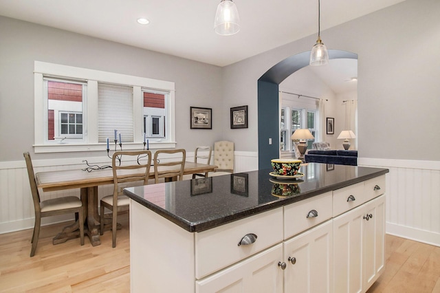 5 Georgia Ct, Pentwater, MI 49449 - kitchen with arched walkways, light wood-style flooring, a wainscoted wall, white cabinets, and decorative light fixtures