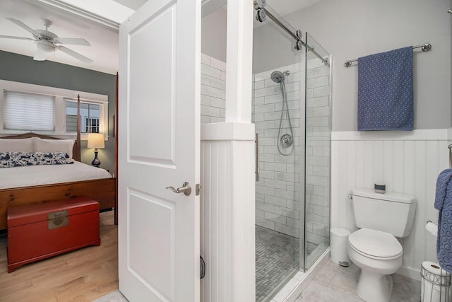 5 Georgia Ct, Pentwater, MI 49449 - full bathroom with a stall shower, wainscoting, toilet, ceiling fan, and wood finished floors