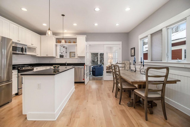 5 Georgia Ct, Pentwater, MI 49449 - kitchen featuring a center island, light wood finished floors, stainless steel appliances, wainscoting, and white cabinetry