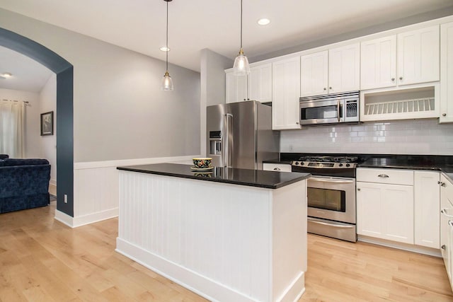 5 Georgia Ct, Pentwater, MI 49449 - kitchen with dark countertops, light wood-style floors, appliances with stainless steel finishes, and arched walkways