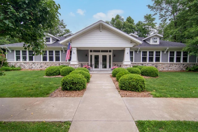 5 Georgia Ct, Pentwater, MI 49449 - view of front facade with stone siding, a front yard, and french doors
