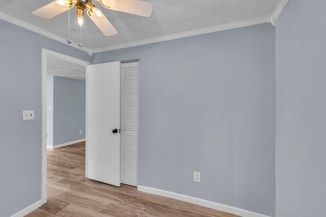 spare room with ceiling fan, light wood-type flooring, and crown molding