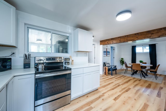 kitchen featuring beamed ceiling, white cabinets, stainless steel electric range oven, and light hardwood / wood-style flooring