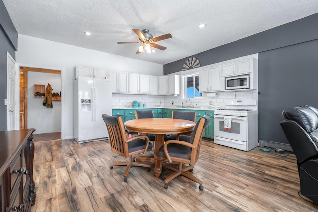 dining space featuring sink, ceiling fan, hardwood / wood-style floors, and a textured ceiling