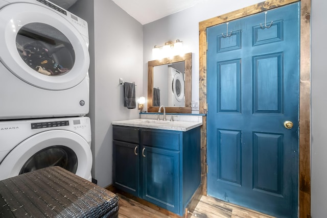 washroom featuring sink, stacked washing maching and dryer, and light wood-type flooring