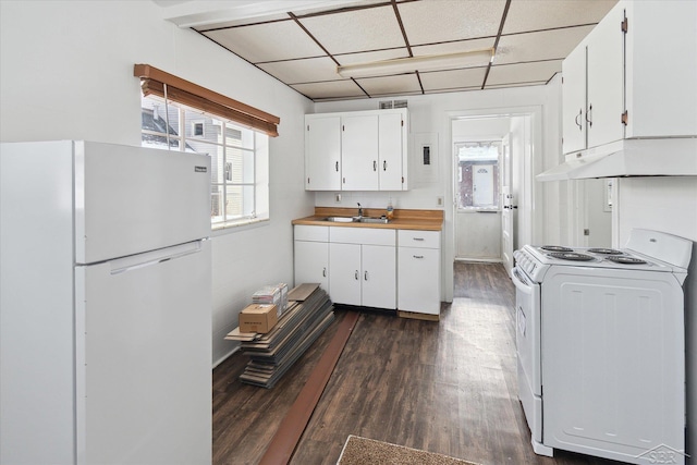 kitchen with white appliances, dark hardwood / wood-style floors, a drop ceiling, white cabinetry, and sink