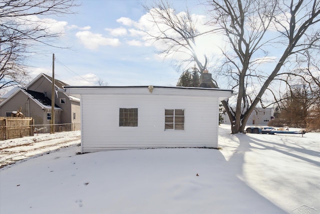 view of snow covered back of property