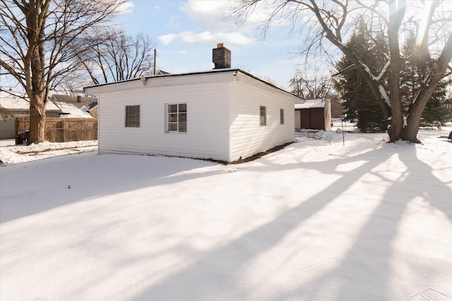 view of snow covered back of property