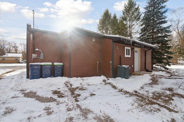 snow covered house featuring central air condition unit