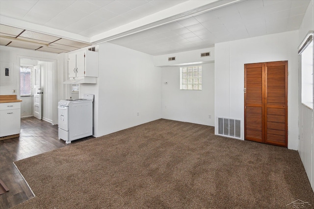 interior space with white stove, dark colored carpet, and white cabinetry